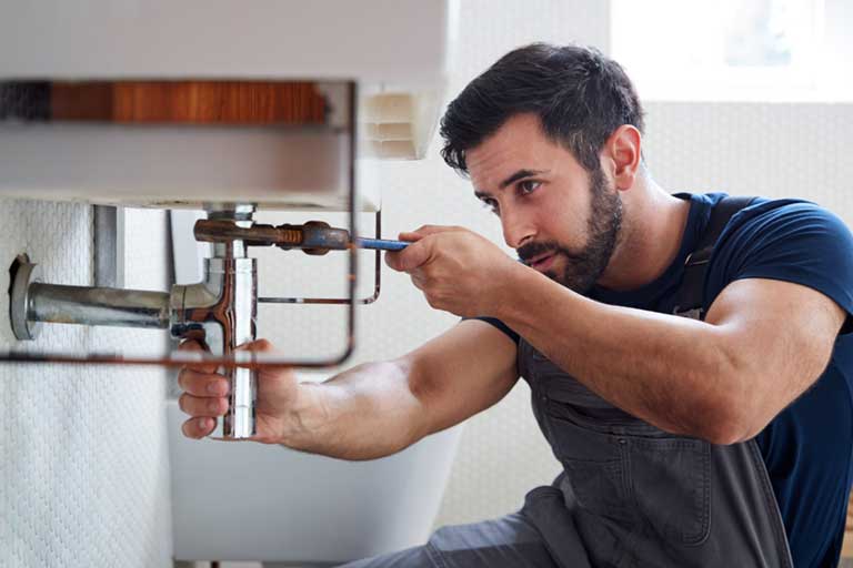 Plumber Working On Leaking Sink in AZ Home