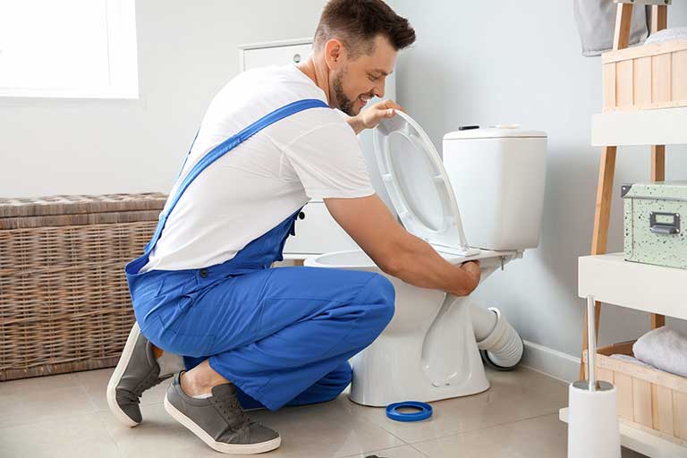 Plumber Repairing Leaking Toilet